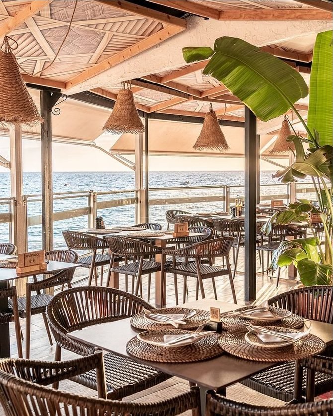 Terraza cubierta del Restaurante La Caleta con lámparas de fibra y mesas puestas frente al mar, La Caleta de Adeje