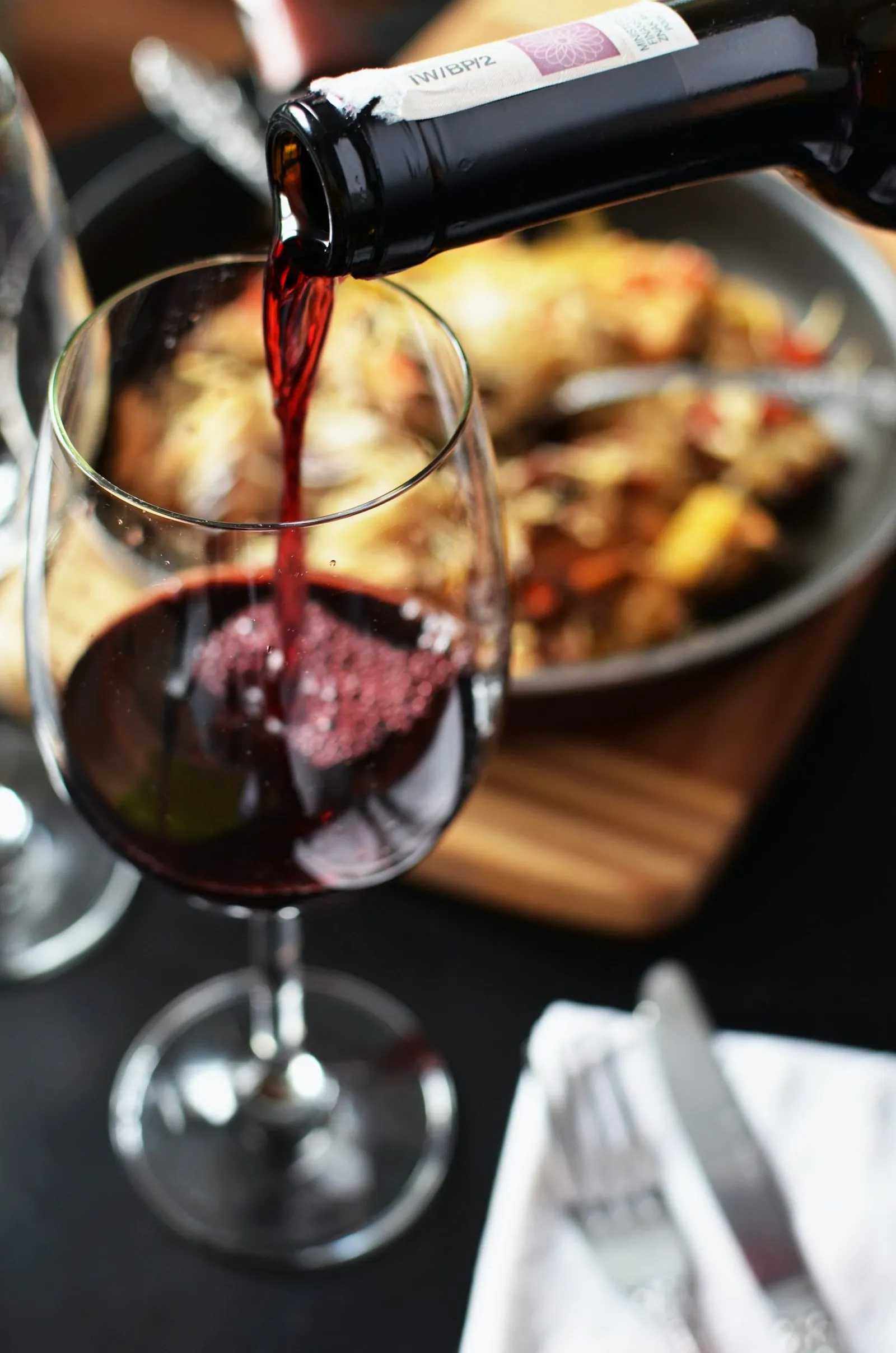 Copa de vino tinto servida junto a un plato en el Restaurante La Caleta, Adeje