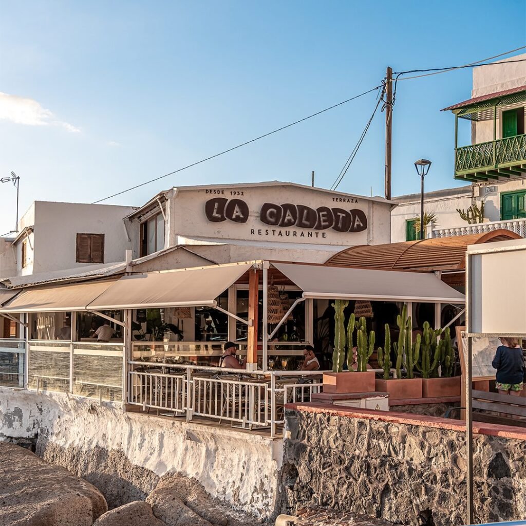 Fachada y terraza del Restaurante La Caleta sobre la costa rocosa de La Caleta de Adeje